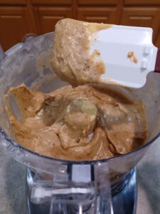 blending dates and tahini with additional ingredients in a food processor