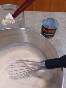 whisking in coconut milk to date-tahini mixture